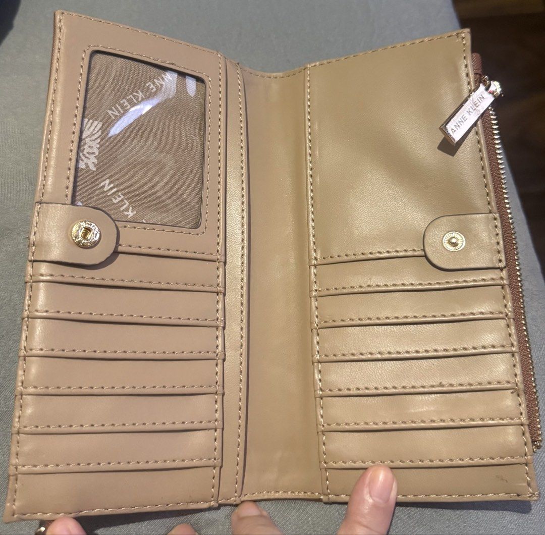 Anne Klein Brown Wristlet Wallet (Category: Wallets & Card holders) located in Cainta. Submitted by mykee1 (Listing ID 1468372578, Image 3). Description: - Brand: Anne Klein - Material: Premium brown textured faux leather with elegant gold hardware - Closure: Secure top zip closure - Features: Includes a matching wrist strap with adjustable buckle detail - Size: Compact and handy, fits easily in your hand or larger everyday bag - Condition: Brand