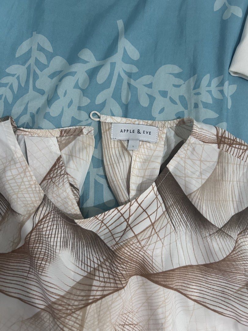 Apple & Eve Brown Abstract Pattern Blouse Size L (Category: Blouses) located in Palo. Submitted by kaleidoscope_676 (Listing ID 1468296142, Image 2). Description: - Brand: Apple & Eve - Size: L - Color/Pattern: Cream base with brown & beige abstract line art print - Design: Short sleeves, crew neckline, back button loop closure - Fit & Fabric: Lightweight, relaxed fit - Condition: Clean and well-maintained - Style Tip: Great neutral everyday top,