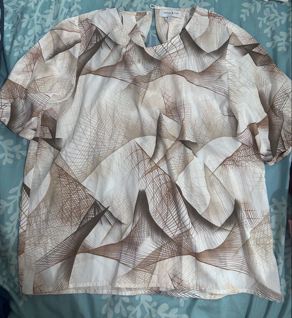 Apple & Eve Brown Abstract Pattern Blouse Size L (Category: Blouses) located in Palo. Submitted by kaleidoscope_676 (Listing ID 1468296142, Image 1). Description: - Brand: Apple & Eve - Size: L - Color/Pattern: Cream base with brown & beige abstract line art print - Design: Short sleeves, crew neckline, back button loop closure - Fit & Fabric: Lightweight, relaxed fit - Condition: Clean and well-maintained - Style Tip: Great neutral everyday top,