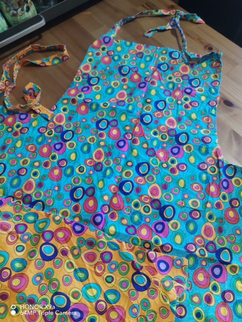 Apron ( Baligtaran) (Category: Towels, Napkins & Holders) located in Muntinlupa City. Submitted by arciagamaryann68 (Listing ID 1468338421, Image 3). Description: - Type: Reversible Apron (Baligtaran) - Design: Colorful circle/bubble pattern on both sides - Colorway: Dual-sided with one orange side and one blue side - Condition: Layered condition 4 (well-maintained and clean) - Ideal Use: Cooking, baking, painting, or household chores - Features: