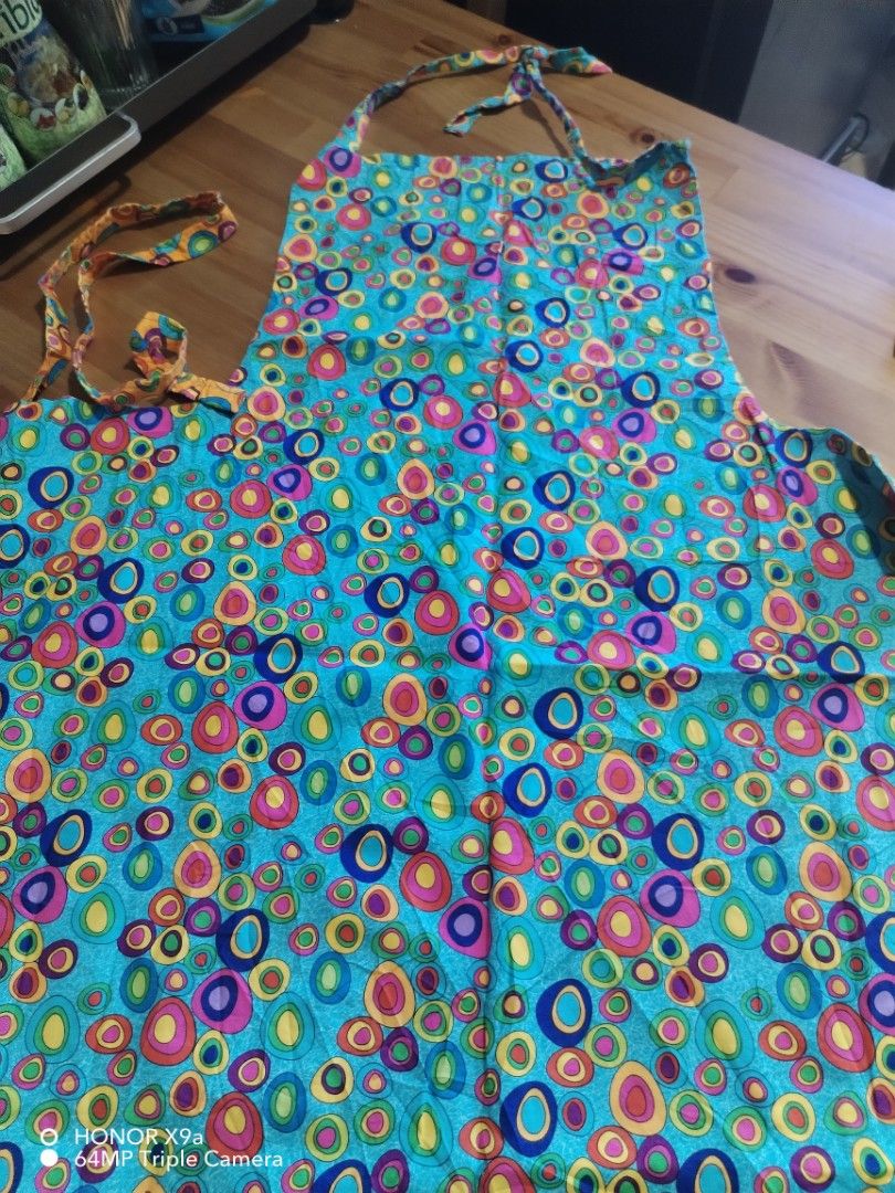 Apron ( Baligtaran) (Category: Towels, Napkins & Holders) located in Muntinlupa City. Submitted by arciagamaryann68 (Listing ID 1468338421, Image 2). Description: - Type: Reversible Apron (Baligtaran) - Design: Colorful circle/bubble pattern on both sides - Colorway: Dual-sided with one orange side and one blue side - Condition: Layered condition 4 (well-maintained and clean) - Ideal Use: Cooking, baking, painting, or household chores - Features:
