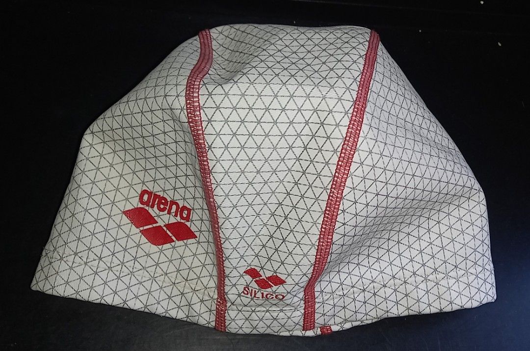 Arena Silico Swim Cap White Red Geometric (Category: Bikinis & Swimsuits) located in Cagayan de Oro. Submitted by edwardryan01984 (Listing ID 1468323459, Image 1). Description: - Brand: Arena - Material: Durable silicone for training and lap swimming - Design: Geometric triangle pattern in white and dark grey with red center stitching - Logos: Red Arena logo on the side and Silico branding near the base - Size: Standard adult sizing.