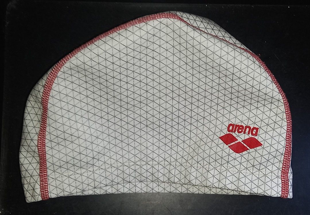 Arena Silico Swim Cap White Red Geometric (Category: Bikinis & Swimsuits) located in Cagayan de Oro. Submitted by edwardryan01984 (Listing ID 1468323459, Image 3). Description: - Brand: Arena - Material: Durable silicone for training and lap swimming - Design: Geometric triangle pattern in white and dark grey with red center stitching - Logos: Red Arena logo on the side and Silico branding near the base - Size: Standard adult sizing.