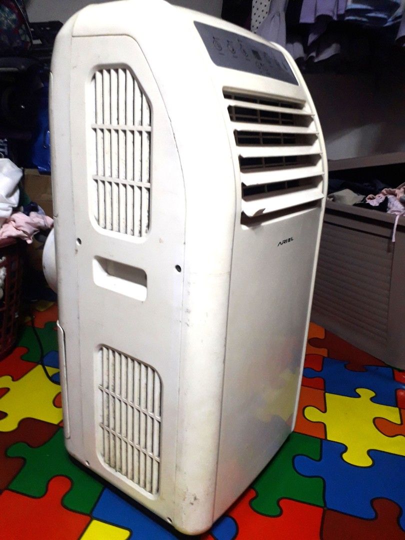 Ariel AMJ100 Portable Air Conditioner (Category: Air Conditioning and Heating) located in Manila. Submitted by maritessa99 (Listing ID 1468499068, Image 2). Description: Ariel portable air conditioner model AMJ100. White unit with control panel on front and plastic exhaust hose included. Cools rooms effectively. Runs on standard power source. Shows some scuffs and dust from normal use over time. Fully functional unit ready to plug in and cool dow