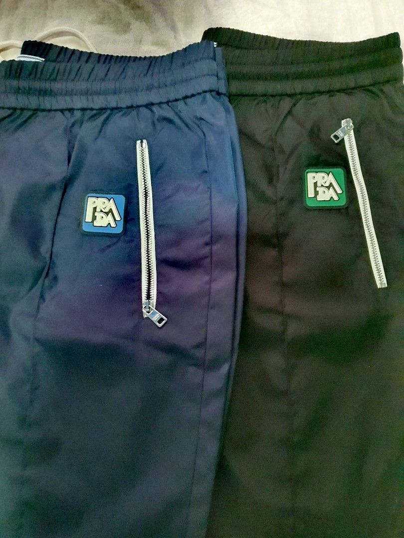 Authentic 💯 2pcs Prada Nylon Jogging Pants Track Pants (Category: Luxury Apparel) located in Tagum. Submitted by maryjanepradalux (Listing ID 1468320273, Image 3). Description: - Brand: Prada (with Milano inner tags) - Material: Premium nylon - Colors Available: Navy Blue and Black - Fit: Relaxed fit for casual wear and streetwear - Features: Elastic waistband with adjustable drawstring, secure zippered front pockets, and iconic rubber logo patc
