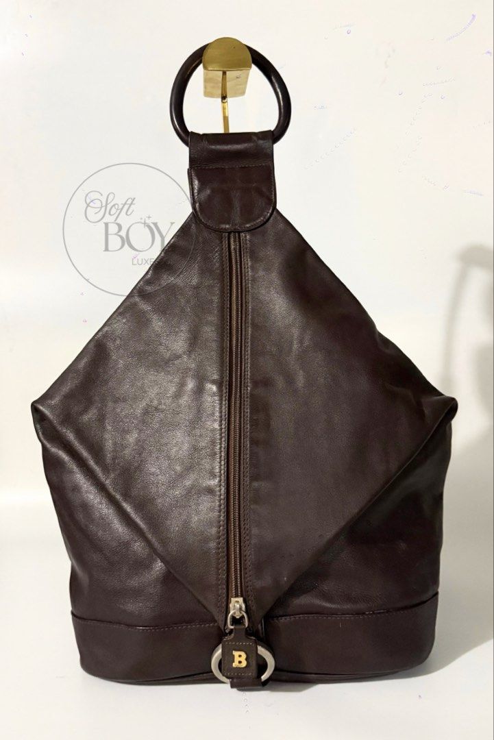 Authentic Bally Leather Convertible Rucksack – Dark Brown (Category: Luxury Bags & Wallets) located in Manila. Submitted by raymondabigan (Listing ID 1468358164, Image 1). Description: Authentic Bally Leather Convertible Rucksack – Dark Brown A distinctive Bally leather rucksack in dark chocolate brown, featuring a rounded top handle and an elongated zippered opening. Its adjustable long strap allows it to be carried as a backpack or worn over th
