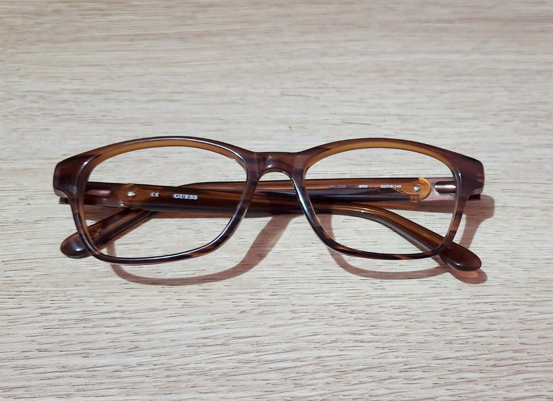Authentic Guess Brown Eyeglasses Frame With Case (Category: Sunglasses & Eyewear) located in Manila. Submitted by crejzshoppe (Listing ID 1468325077, Image 1). Description: 52 -16-140 Frame only with original case lightly used in very good condition - Brand: Guess - Color/Pattern: Tortoise brown acetate - Shape: Classic rectangular - Details: Metal hardware medallion on temple with Guess Los Angeles branding - Inclusions: Original leopard print h