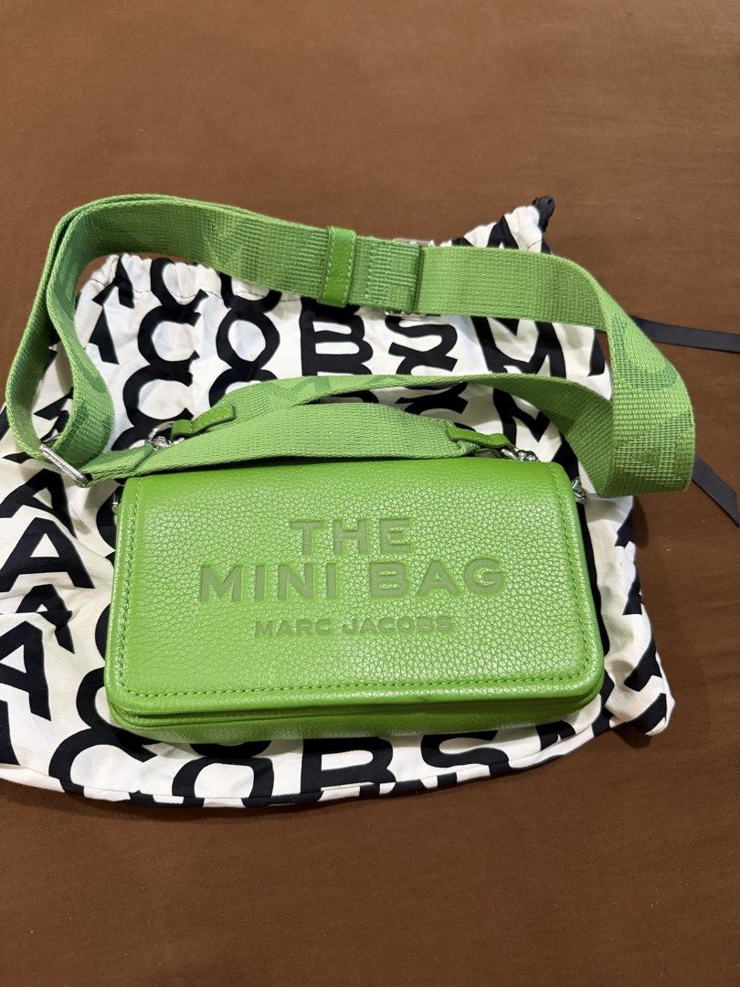Authentic Marc Jacobs The Mini Bag Green (Category: Luxury Bags & Wallets) located in Quezon City. Submitted by rc1415 (Listing ID 1468356484, Image 2). Description: - Brand: Marc Jacobs - Style: Leather crossbody bag in a vibrant bright green shade - Exterior: Embossed 'THE MINI BAG' text on the front with silver-tone hardware - Interior: Vibrant yellow lining and a playful hidden quote 'MY OTHER BAG IS THE TOTE BAG' under the flap - Strap: Thic