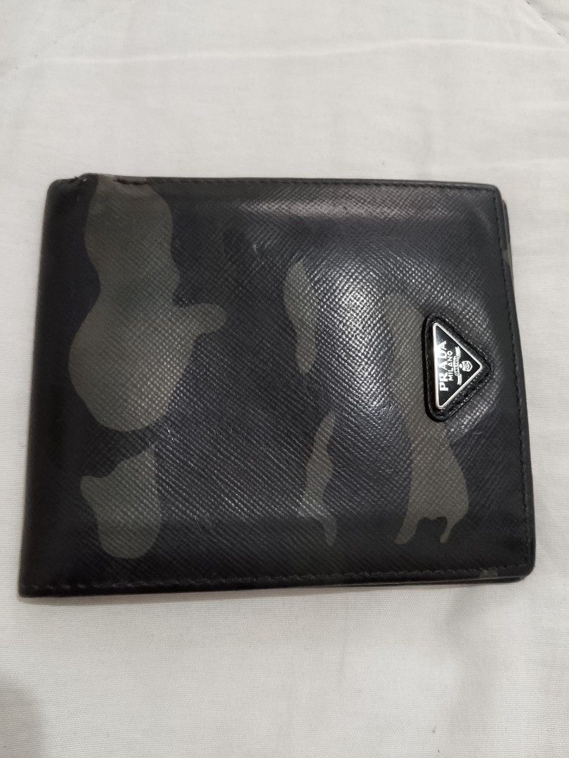 Authentic Prada Saffiano Camouflage Bifold Wallet (Category: Luxury Bags & Wallets) located in Manila. Submitted by anvicnicajeff (Listing ID 1468457979, Image 3). Description: - Brand: Prada -Authentic - Style: Bifold wallet - Material: Saffiano leather with black camouflage pattern - Hardware: Iconic silver-tone metal triangle logo - Interior: Multiple card slots and bill compartment with 'Made in Italy' tag - Condition: Shows normal wear aroun
