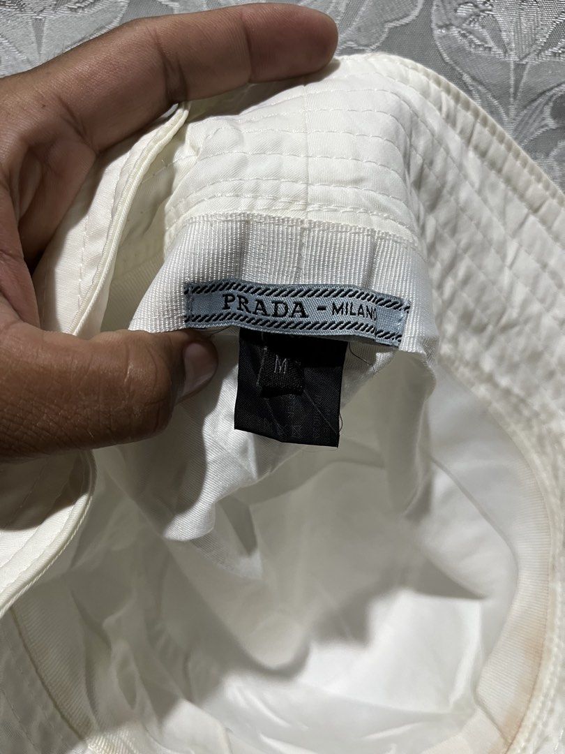 Authentic Prada White Re-Nylon Bucket Hat (Category: Hats & Beanies) located in General Santos City (Dadiangas). Submitted by thiftnibadi3 (Listing ID 1468420814, Image 3). Description: - Brand: Prada - Item: Bucket Hat - Color: Clean White - Size: M (tag inside) - Material: Polyester and cotton blend - Details: Iconic enameled metal triangle logo - Care: Dry clean only - Condition: Ready to wear, classic streetwear essential.