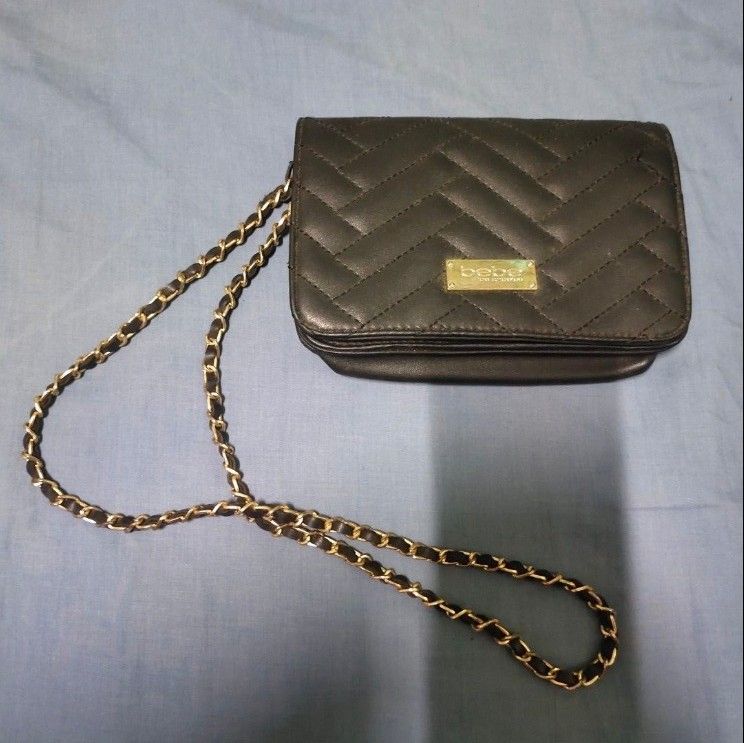 bebe Black Quilted Chain Strap Crossbody Bag (Category: Cross-body Bags) located in Quezon City. Submitted by dncpreloved (Listing ID 1468355418, Image 1). Description: - Brand: bebe - Color & Style: Black quilted crossbody with chevron pattern - Hardware: Elegant gold-tone chain strap and matching hardware - Closure & Interior: Secure magnetic closure, includes an interior zipper pocket and card slots - Size: Compact, perfect for daily essential