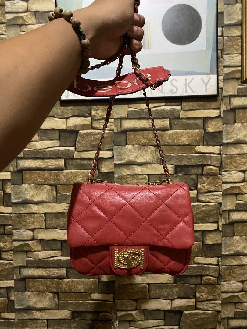 bebe Red Quilted Shoulder Bag with Gold Chain (Category: Luxury Bags & Wallets) located in Caloocan City. Submitted by cleverwater.ba6482 (Listing ID 1468443389, Image 2). Description: - Brand: bebe - Color: Bright red with luxury gold-tone hardware - Design: Classic quilted pattern with front metallic logo clasp - Strap: Gold chain interwoven with red material, featuring a branded shoulder pad - Extras: Cute hanging gold 'bebe' letter charms on 