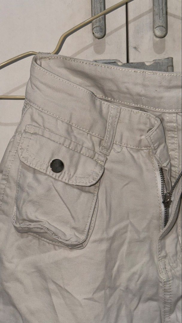 Beige Cargo Pants Y2K Utility Trousers (Category: Jeans) located in Taguig. Submitted by deguzmanke83356 (Listing ID 1468361181, Image 3). Description: - Color: Beige - Style: Utility cargo pants with straight leg cut and mid to high rise waist - Material: Sturdy twill fabric featuring contrast stitching - Pockets: Multiple front and side pockets with snap-button closures, plus two back welt pockets - Closure: Zip fly with button closure - Perfec