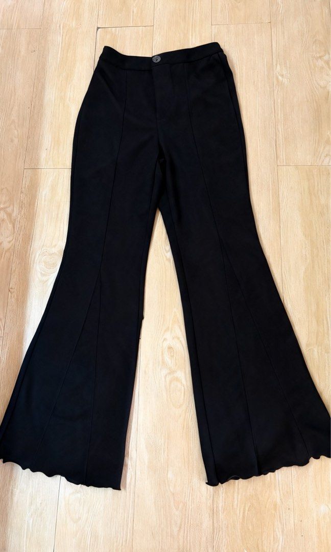 Black flared trousers high waist pants (Category: Jeans) located in Marikina City. Submitted by phelinky_finds (Listing ID 1468334960, Image 1). Description: 🛍️ DESCRIPTION: - Color: Classic Black - Fit: High-waisted with a single button closure - Style: Flared trousers with a wide bell-bottom hem and wavy edge finish - Details: Stitched center creases down the front of both legs - Fabric: Smooth, premium material with a structured drape ✅ Condi