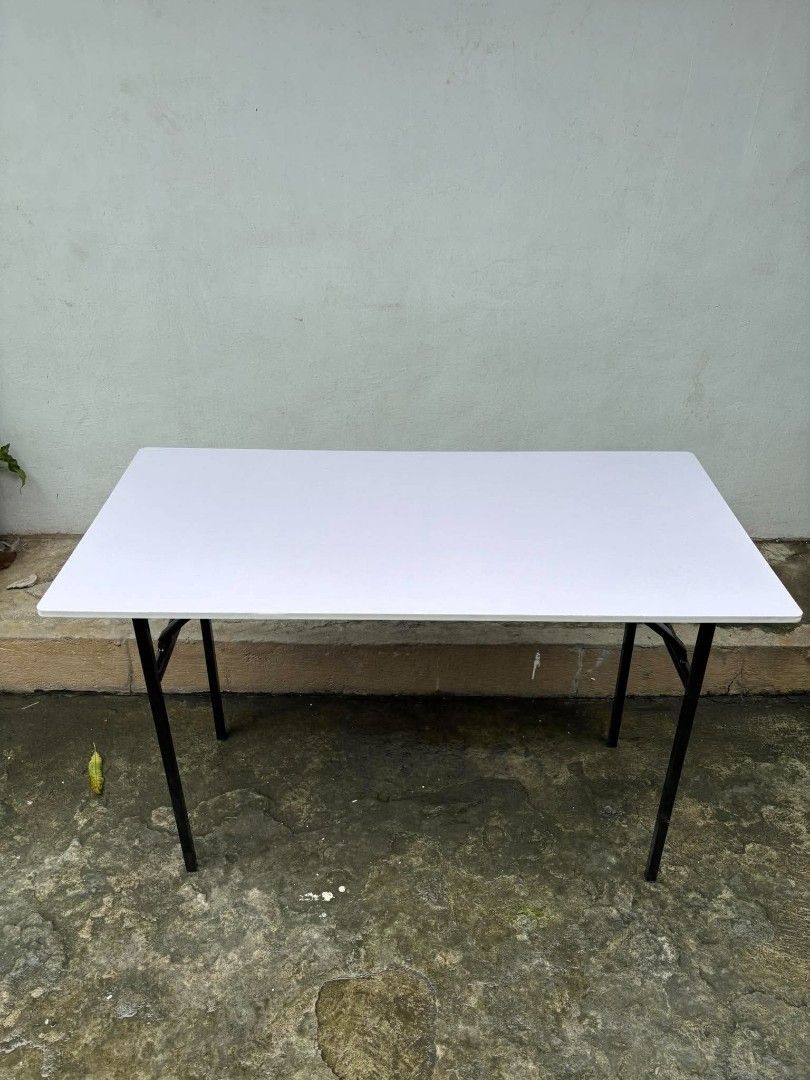 Black Folding Utility Table with Metal Legs (Category: Tables & Sets) located in Manila. Submitted by ajimdolor012051 (Listing ID 1468326232, Image 2). Description: - Rectangular table with a sleek black top and reddish-brown wood finish underneath - Sturdy black metal folding legs for easy storage and transport - Stable and reliable setup on any flat surface - Ideal extra surface for studying, working, dining, or hosting gatherings - Space-savin