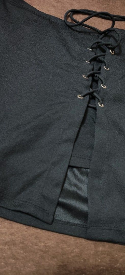Black lace-up front mini skirt (Category: Skirts) located in Manila. Submitted by snz_shop (Listing ID 1468472713, Image 2). Description: FREE FOR BUYER ONLY ‼️ - Color: Black - Style: Mini skirt with a trendy lace-up front split - Details: Silver grommets with a black cord - Comfort: Built-in lining underneath the split for added coverage - Material: Smooth fabric with a unique textured surface - Condition: Brand new / Excellent (ready to wear).