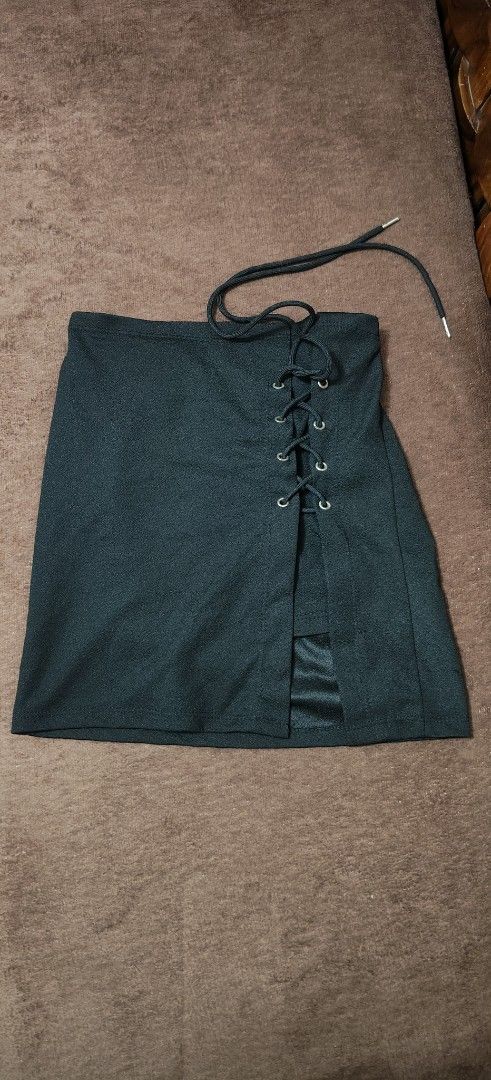 Black lace-up front mini skirt (Category: Skirts) located in Manila. Submitted by snz_shop (Listing ID 1468472713, Image 3). Description: FREE FOR BUYER ONLY ‼️ - Color: Black - Style: Mini skirt with a trendy lace-up front split - Details: Silver grommets with a black cord - Comfort: Built-in lining underneath the split for added coverage - Material: Smooth fabric with a unique textured surface - Condition: Brand new / Excellent (ready to wear).