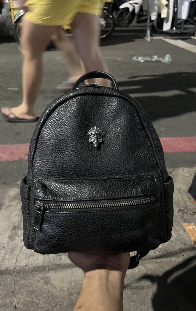 Black Leather Mini Backpack with silver Man Emblem (Category: Backpacks) located in Marikina City. Submitted by baron0923 (Listing ID 1468453785, Image 2). Description: - Stylish black pebble leather mini backpack - Distinctive metal Green Man leaf face emblem on the front - Secure main compartment with smooth zipper closure - Handy front zipper pocket and side slip pockets - Comfortable adjustable straps and top grab handle - Clean interior lini