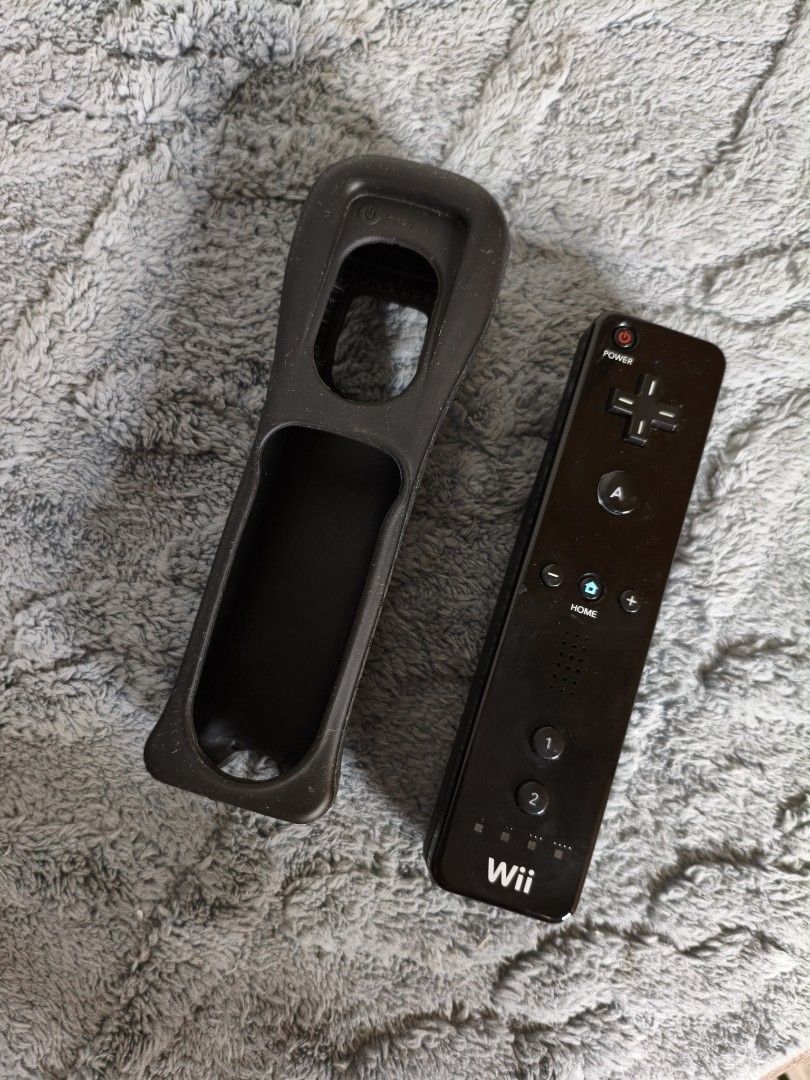 Black Nintendo Wii Remote Controller with Silicone (Category: Controllers) located in Lubao. Submitted by aczcollectibles (Listing ID 1468352649, Image 1). Description: Original black Nintendo Wii Remote with matching silicone case..