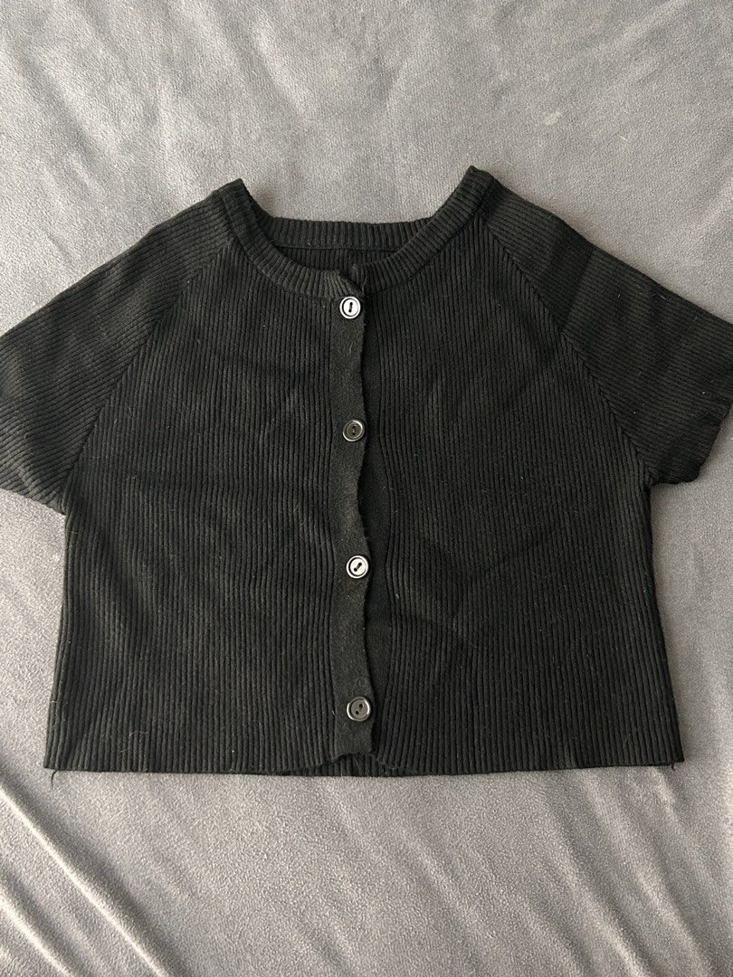 Black ribbed short sleeve button up crop top (Category: Blouses) located in Pasig City. Submitted by cha.declutterz (Listing ID 1468334972, Image 1). Description: - Color: Black - Free size (S-M) - Style: Short-sleeve ribbed cardigan top with front buttons - Fit: Cropped length, round neckline - Material: Soft and stretchy knit - Pairing: Great for matching with high-waisted pants or skirts.