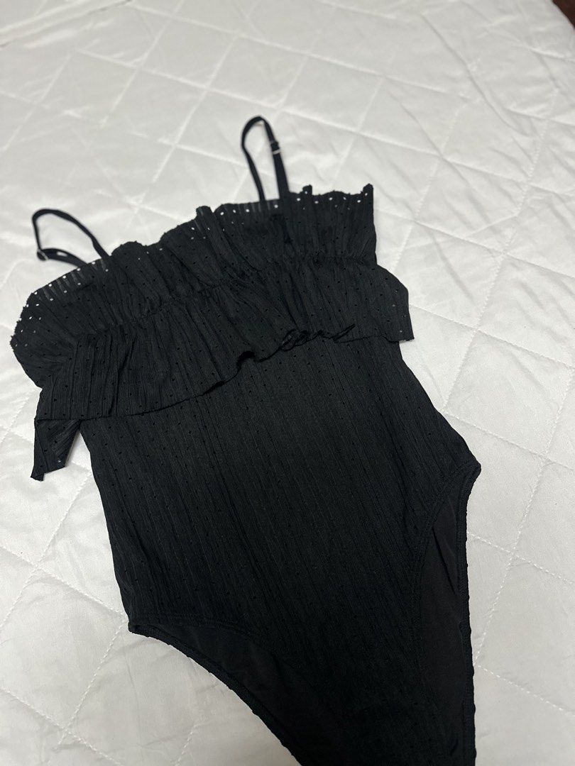 Black Ruffle One-Piece Swimsuit (Category: Bikinis & Swimsuits) located in Valenzuela. Submitted by prelovedbyramsie (Listing ID 1468404758, Image 2). Description: Black one-piece swimsuit with textured dotted fabric. Flouncy ruffle overlay across the chest. Adjustable thin shoulder straps with metal sliders. High-cut leg openings. Clean back design. Simple and classic look for the beach or pool..