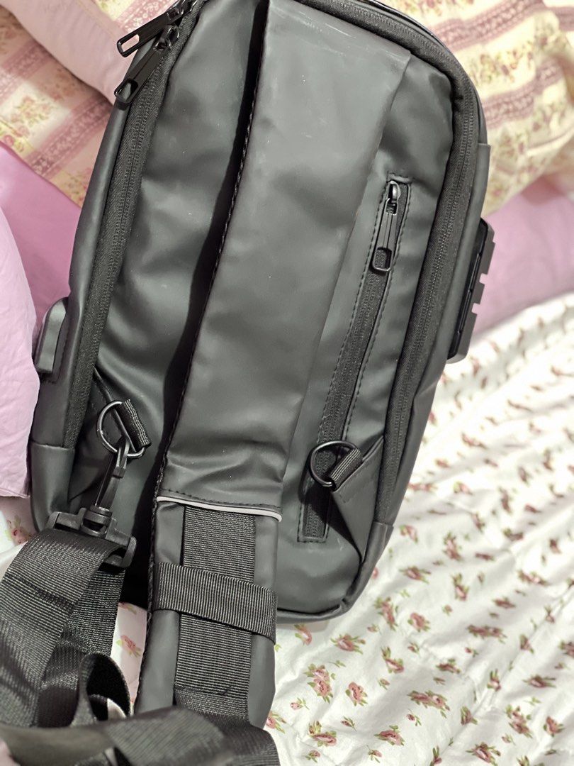 Black Sling Bag with Combination Lock and USB Port (Category: Sling Bags) located in Pasig City. Submitted by morilove (Listing ID 1468303436, Image 2). Description: - Color: Sleek black with a minimalist design - Security: Built-in combination lock to keep your belongings safe - Organization: Multiple zippered compartments both inside and out - Comfort & Durability: Adjustable strap with sturdy D-rings - Versatility: Ideal for daily commuting, t