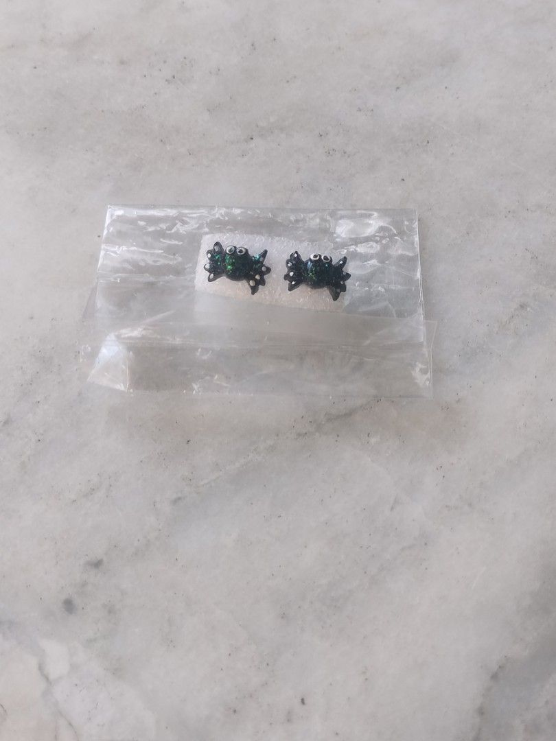 Black Spider Stud Earrings with Green Glitter (Category: Earrings) located in Las Pinas. Submitted by cozychic19 (Listing ID 1468381363, Image 1). Description: Cute little black spider stud earrings with shiny green glitter on the back. White googly eyes make them extra fun. Butterfly backs included. Still in the original plastic packaging and foam holder. Perfect for Halloween or everyday alternative style..