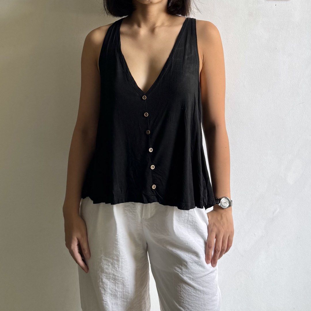 Black V-neck button down sleeveless top with low back (Category: Sleeveless) located in Bulacan. Submitted by _arislmt (Listing ID 1468499623, Image 2). Description: - Color: Black - Style: Deep V-neck with wooden front buttons and low scoop back - Fit: Relaxed, flowy, and comfortable - Material: Lightweight and breathable, ideal for warm weather or layering - Condition: Clean, worn only a few times - Fits M-L.
