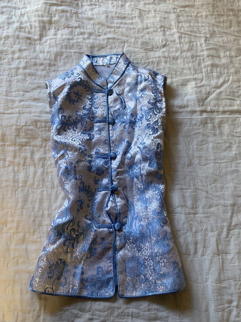 Blue and silver floral patterned mandarin collar sleeveless top (Category: Sleeveless) located in Sarangani. Submitted by solune_clo (Listing ID 1468405168, Image 1). Description: - Color & Style: Light blue and silver sleeveless top with a traditional mandarin collar - Pattern: Intricate all-over floral brocade - Details: Fastens down the front with matching fabric knot buttons - Fit: Fitted silhouette with a straight hem - Material: Lightweight
