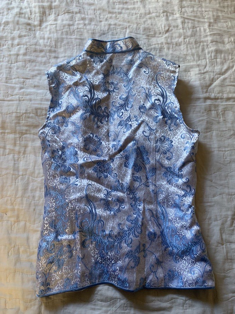 Blue and silver floral patterned mandarin collar sleeveless top (Category: Sleeveless) located in Sarangani. Submitted by solune_clo (Listing ID 1468405168, Image 2). Description: - Color & Style: Light blue and silver sleeveless top with a traditional mandarin collar - Pattern: Intricate all-over floral brocade - Details: Fastens down the front with matching fabric knot buttons - Fit: Fitted silhouette with a straight hem - Material: Lightweight