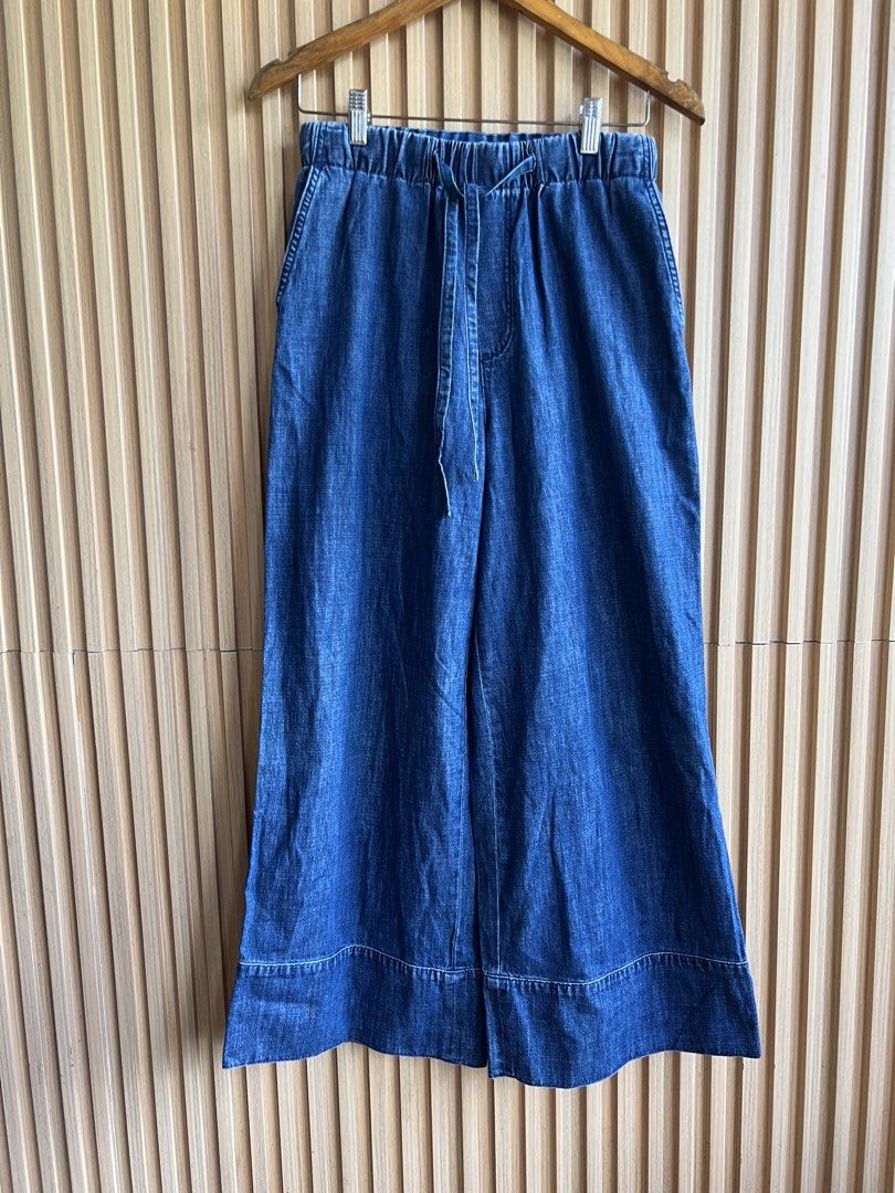 Blue Denim Wide Leg Drawstring Pants (Category: Jeans) located in Lipa City. Submitted by thyra06 (Listing ID 1468321719, Image 2). Description: - Style: Casual wide-leg denim pants - Waist: Elastic waistband with functional front drawstring - Pockets: Two back patch pockets with chic silver V hardware - Wash: Deep blue wash with subtle fading - Details: Thick stitched cuffs at the hem - Fit: Relaxed and comfortable, great for everyday wear.