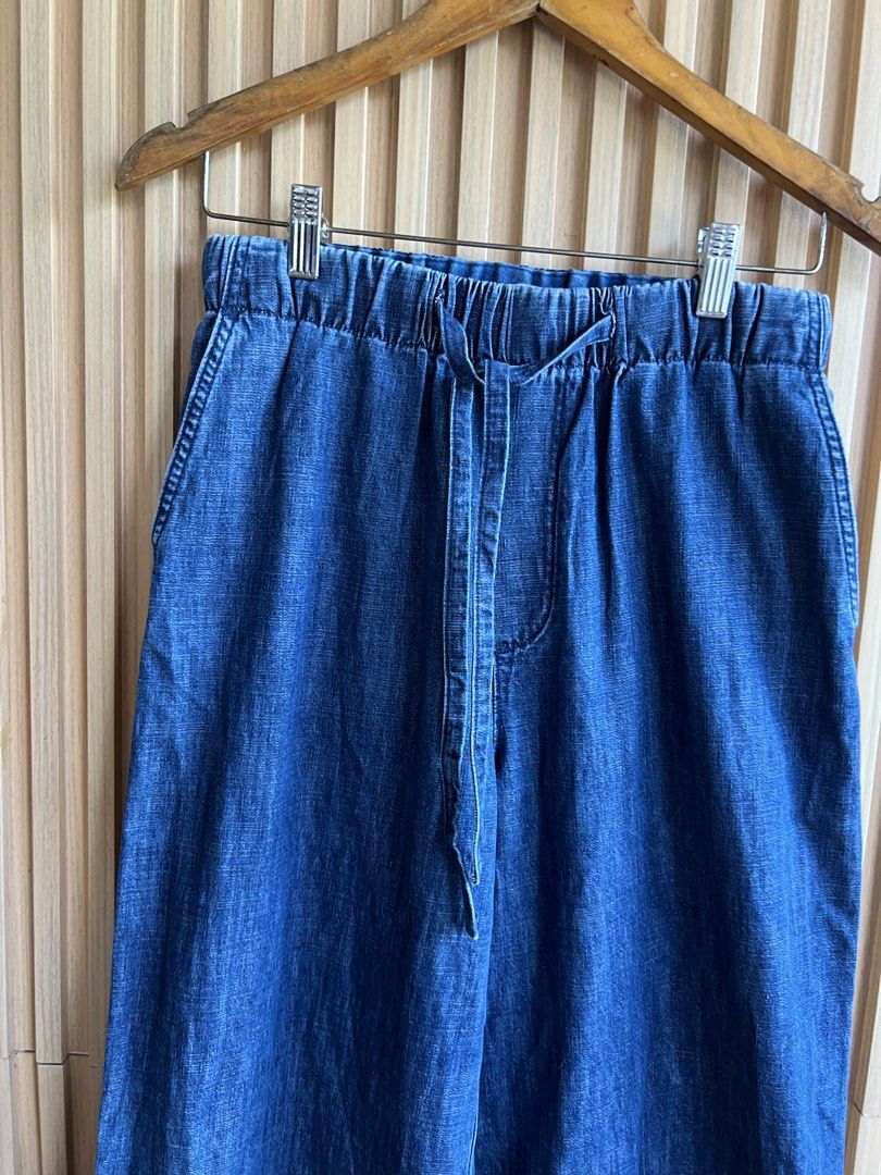 Blue Denim Wide Leg Drawstring Pants (Category: Jeans) located in Lipa City. Submitted by thyra06 (Listing ID 1468321719, Image 3). Description: - Style: Casual wide-leg denim pants - Waist: Elastic waistband with functional front drawstring - Pockets: Two back patch pockets with chic silver V hardware - Wash: Deep blue wash with subtle fading - Details: Thick stitched cuffs at the hem - Fit: Relaxed and comfortable, great for everyday wear.
