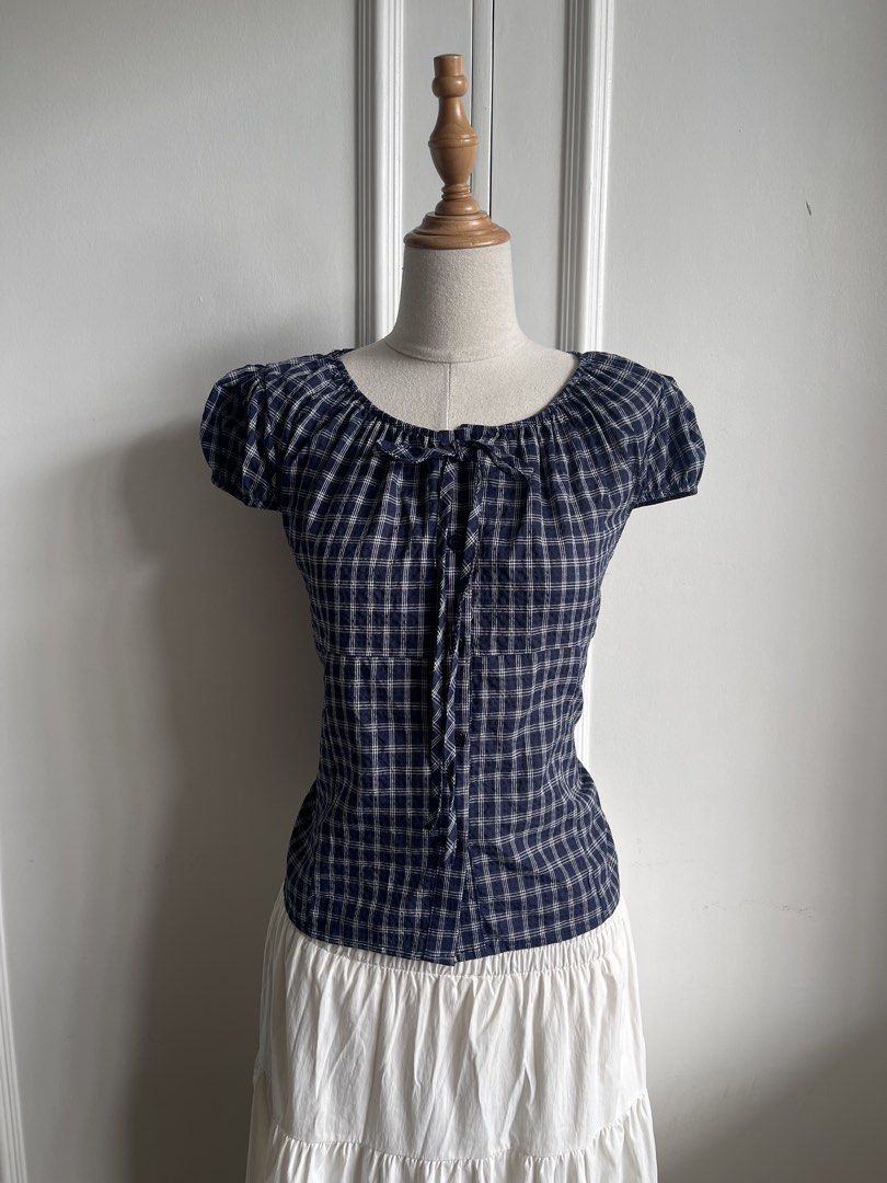 Blue Plaid Short Sleeve Tie-Front Blouse (Category: Blouses) located in Cavite. Submitted by devilourea (Listing ID 1468302596, Image 1). Description: - Classic navy blue and white plaid pattern - Trendy square neckline with cute front tie detail - Short puff sleeves and functional center button-down - Flattering slim fit that hits right at the waist - Pairs effortlessly with high-waisted jeans or skirts - Condition: Brand new / Excellent - Mode 
