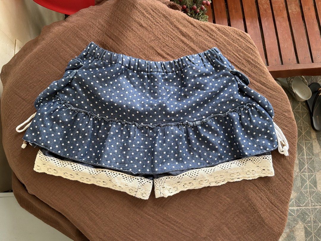 Blue Polka Dot Skort with Lace Trim (Category: Skirts) located in Dumaguete. Submitted by _l1lyy_ (Listing ID 1468343965, Image 2). Description: - Fit: M-L - Blue denim-style skort with adorable white polka dots - Layered ruffle design finished with charming beige crochet lace trim - Adjustable side lacing with thick white ropes and metallic grommets - Comfortable elastic waistband for an easy and flexible fit - Cute, playful piece perfect for ca