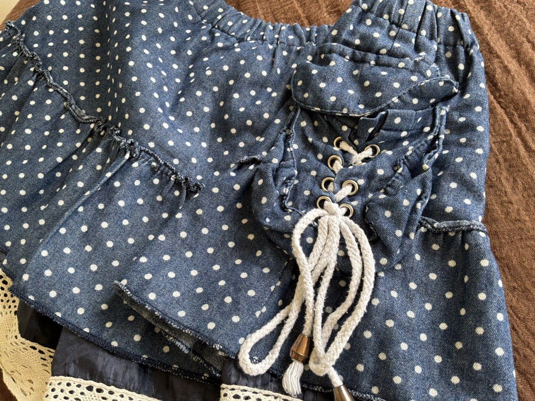Blue Polka Dot Skort with Lace Trim (Category: Skirts) located in Dumaguete. Submitted by _l1lyy_ (Listing ID 1468343965, Image 3). Description: - Fit: M-L - Blue denim-style skort with adorable white polka dots - Layered ruffle design finished with charming beige crochet lace trim - Adjustable side lacing with thick white ropes and metallic grommets - Comfortable elastic waistband for an easy and flexible fit - Cute, playful piece perfect for ca