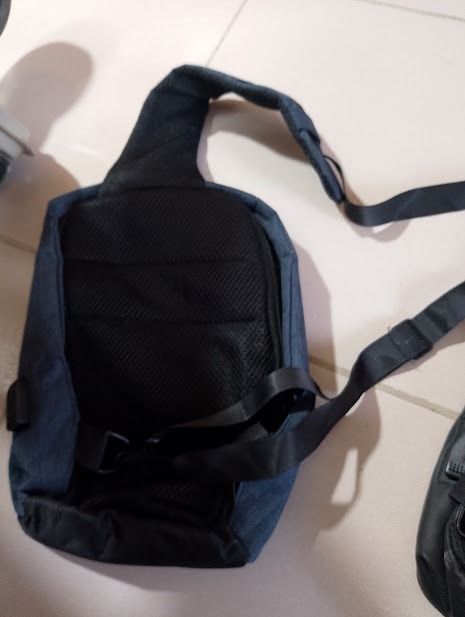 Blue Sling Bag Crossbody Backpack (Category: Cross-body Bags) located in Quezon City. Submitted by susmaryosep1 (Listing ID 1468348002, Image 2). Description: - Color: Navy blue - Condition: Used with minor wear on straps - Comfort: Mesh padded back panel for breathability - Strap: Adjustable shoulder strap with buckle closure - Compartment: Secure zippered main compartment - Usage: Compact size, ideal for daily commutes or casual outings 300.