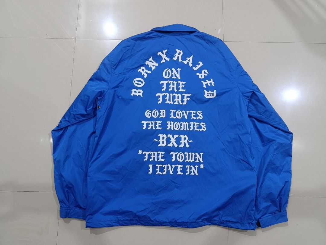 BORN X RAISED Coach Jacket (Category: Coats, Jackets and Outerwear) located in Davao. Submitted by idioticthrifter (Listing ID 1468463661, Image 2). Description: - Brand: Born X Raised - Style: Coach Jacket / Streetwear - Color: Bold Blue with contrasting inner lining - Size: Large (L) 24 width x 29 length - Closure: Snap button with zipper detail underneath - Details: Large white "On the turf, God loves the homies BXR" back graphic, small chest 