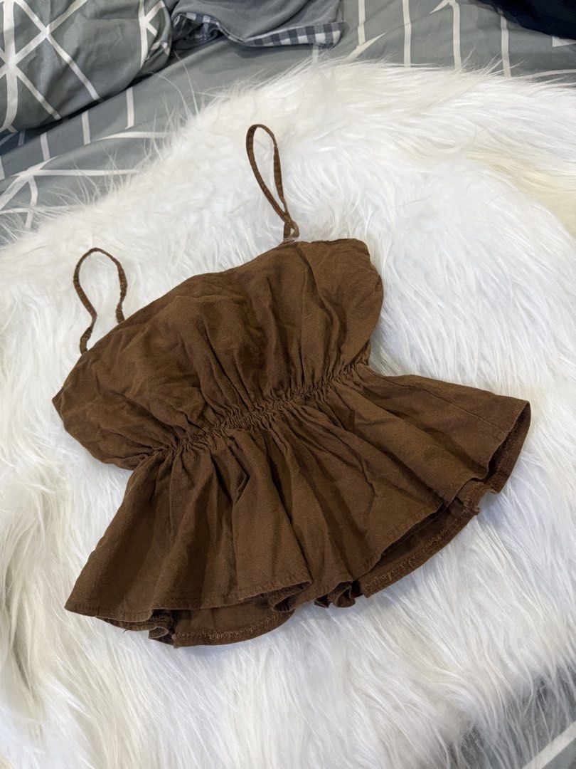 Brown Spaghetti Strap Peplum Camisole Top (Category: Sleeveless) located in Las Pinas. Submitted by juls_mp (Listing ID 1468399862, Image 1). Description: - Color: Brown - Design: Thin spaghetti straps with gathered front smocking - Fit: Flared, flowy peplum hem - Material: Lightweight and comfortable fabric - Styling: Pairs effortlessly with high-waisted jeans or skirts for everyday casual looks.