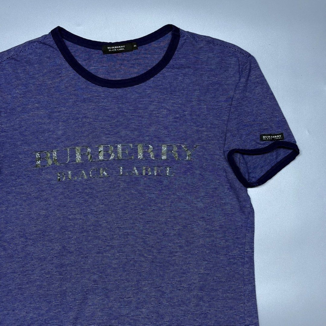 Burberry Black Label Blue Striped Ringer (Category: Luxury Apparel) located in Kabacan. Submitted by rags2penny.phl (Listing ID 1468336645, Image 2). Description: - Brand: Burberry Black Label - Color: Blue with thin horizontal stripes and dark navy collar/cuffs - Design: Large chest logo with unique floral pattern inside letters, plus small sleeve brand tag - Size: 3 (fits like a medium) - Material: Soft and lightweight 100% cotton - Condition: 