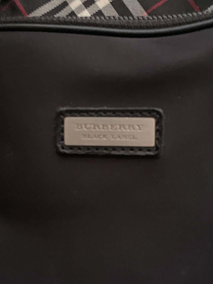 Burberry Black Label Laptop Briefcase Bag (Category: Briefcases) located in Manila. Submitted by buyingprelovedukayukay (Listing ID 1468322232, Image 3). Description: - Authentic Burberry Black Label briefcase in classic black - Signature check pattern trim along the top zipper - Premium leather dual top carry handles - Stylish metal brand plaque on the front exterior - Durable fabric-lined interior with stitched brand label tag - Clean, professi