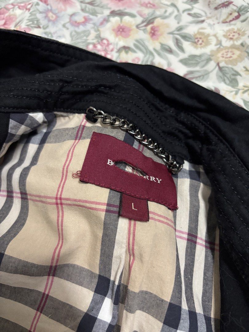 Burberry Black Trench Coat Size L (Category: Coats, Jackets and Outerwear) located in Manila. Submitted by urthrifthany (Listing ID 1468454985, Image 3). Description: - Brand: Burberry - Color: Classic Black with Nova Check lining - Size: Large (L) - Style: Double-breasted button front with matching belt and buckle - Details: Shoulder epaulets, belted cuffs, and chain hanging loop at the collar - Condition: Excellent, timeless piece for cooler we
