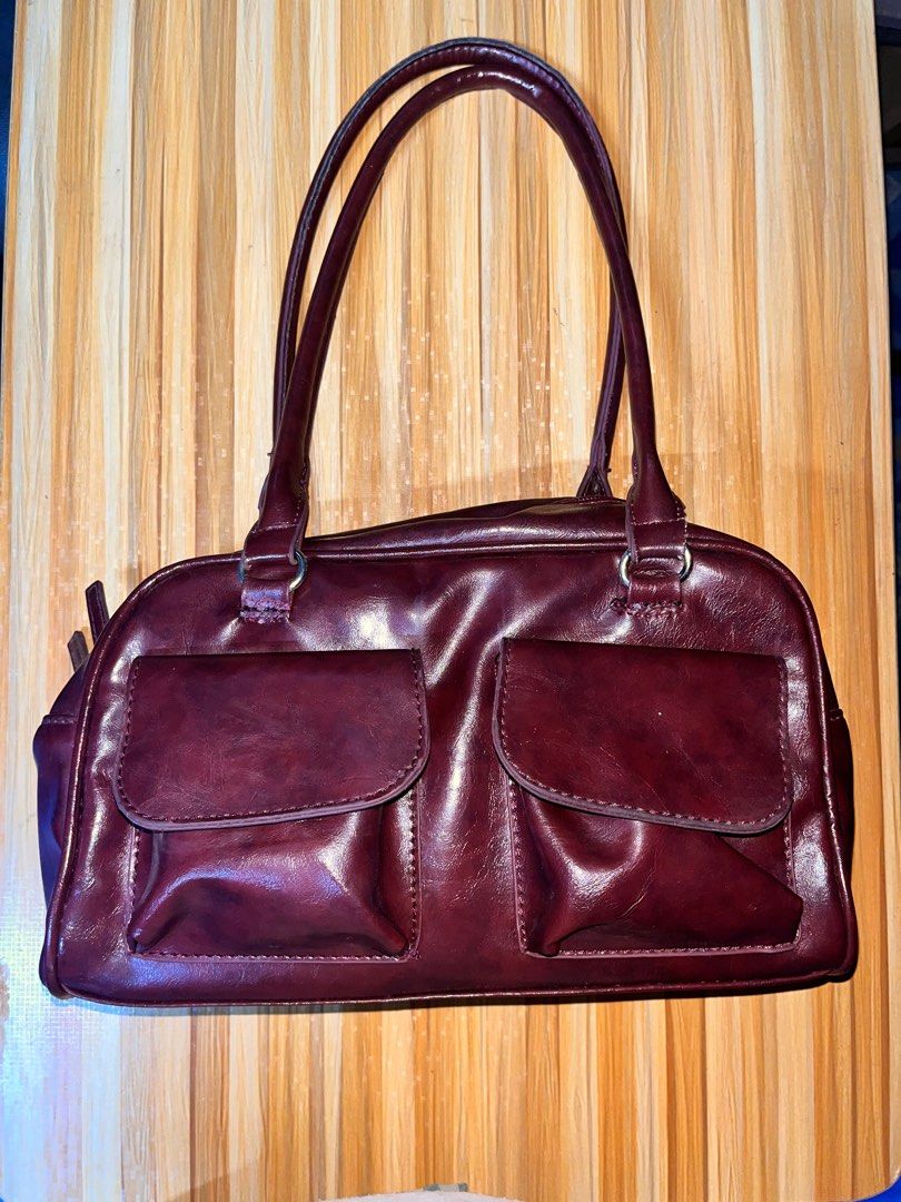 Burgundy Shoulder Bag with Dual Front Pockets (Category: Shoulder Bags) located in Naic. Submitted by nasaryn_ (Listing ID 1468404649, Image 1). Description: Burgundy faux leather shoulder bag with two front flap pockets. Main zip compartment lined in black fabric, fits a compact umbrella easily. Dual shoulder straps attached with silver-tone rings. Clean interior with an extra zippered side pocket. Good everyday size for daily essentials. with f