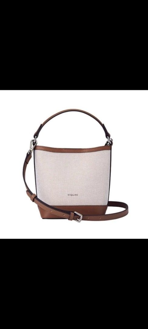 by ESQUIRE Canvas Bucket Bag (Category: Shoulder Bags) located in Manila. Submitted by daisyduck09 (Listing ID 1468362905, Image 2). Description: - Brand: ESQUIRE bucket bag - Color/Material: Cream canvas with brown faux leather trim - Condition: Brand new, never used, with clean interior and exterior (clear protective wrapping still on handle and strap) - Versatility: Includes a short top handle and a detachable, adjustable shoulder strap - Incl