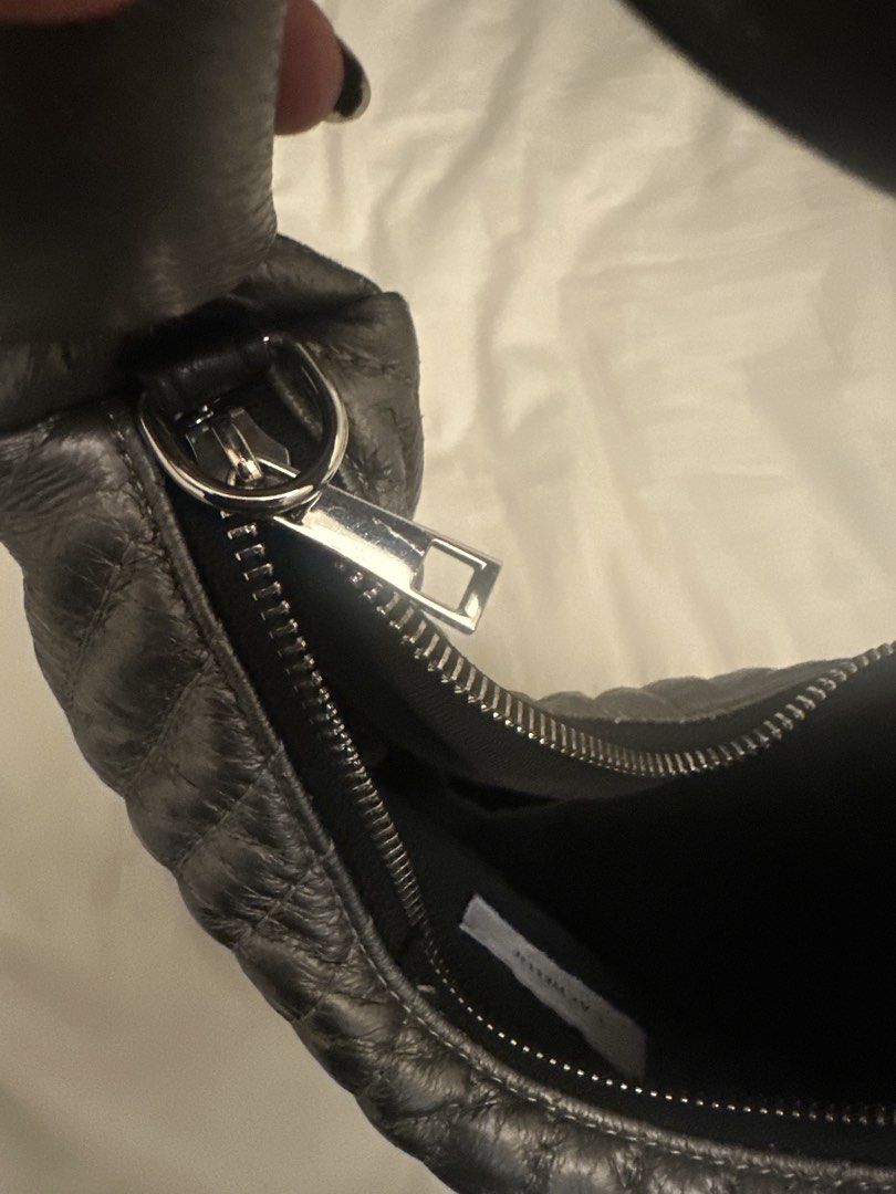 Cachellie Metallic Silver Quilted Shoulder Bag (Category: Luxury Bags & Wallets) located in Pasig City. Submitted by cosmicjuice08 (Listing ID 1468405962, Image 3). Description: - Brand: Cachellie - Color: Metallic silver with vertical quilting - Handle: Unique twisted design with knotted ends - Closure: Secure top zip closure - Interior: Black fabric lining with a slip pocket and brand tag - Size: Compact, perfect for daily essentials A lightwei
