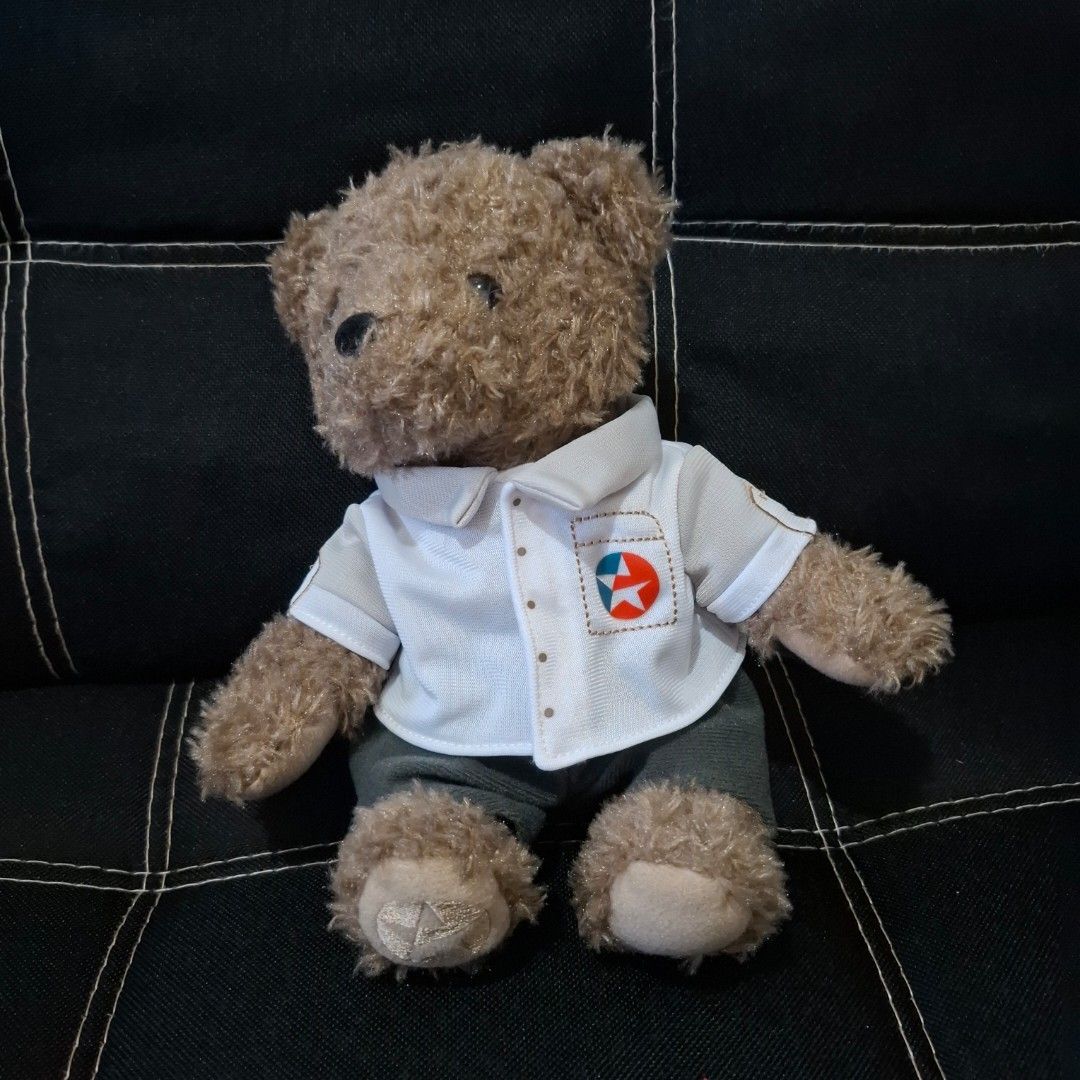 Caltex Teddy Bear (Category: Plushies & Soft Toys) located in Baliuag. Submitted by ahgashop. (Listing ID 1468297417, Image 1). Description: - Caltex Teddy Bear - Dressed in a white button-up shirt with 'Enjoy The Journey' print and Caltex star logo pocket - Features cute embroidered star details on the footpads - Perfect for collectors and gift ideas.