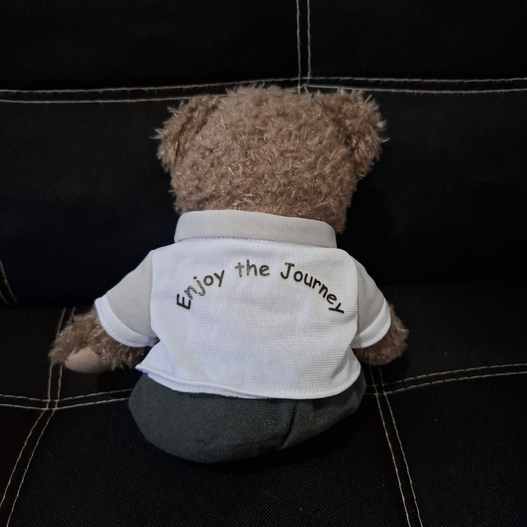 Caltex Teddy Bear (Category: Plushies & Soft Toys) located in Baliuag. Submitted by ahgashop. (Listing ID 1468297417, Image 2). Description: - Caltex Teddy Bear - Dressed in a white button-up shirt with 'Enjoy The Journey' print and Caltex star logo pocket - Features cute embroidered star details on the footpads - Perfect for collectors and gift ideas.