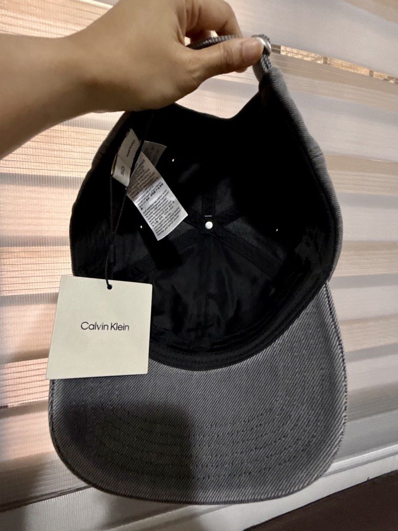Calvin Klein Cap with CK logo-Denim Grey (Category: Caps & Hats) located in Mandaluyong City. Submitted by shoppingmilesph (Listing ID 1468451338, Image 3). Description: ✔️Original & brand new Calvin Klein 💯 ✔️Comes with attached CK tags ✔️Color: Denim Grey ✔️Design: Embroidered logo on front, classic curved brim, and stitched eyelets ✔️Fit: Adjustable strap at the back for a custom fit.