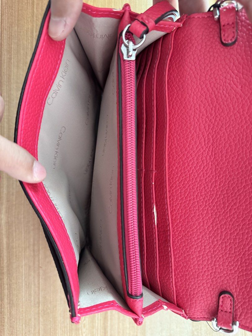 Calvin Klein Pink Crossbody Bag (Category: Cross-body Bags) located in Valenzuela. Submitted by declutterlangpo (Listing ID 1468298903, Image 3). Description: - Brand new with original tags attached (MSRP $148.00) - Eye-catching bright pink color with a chic silver chain strap - Organized interior with multiple compartments, card slots, and a middle zipped pocket - Tag code: H2ER5J3 - Flaw note: Minor paint chipping at the bottom corner edge (pri
