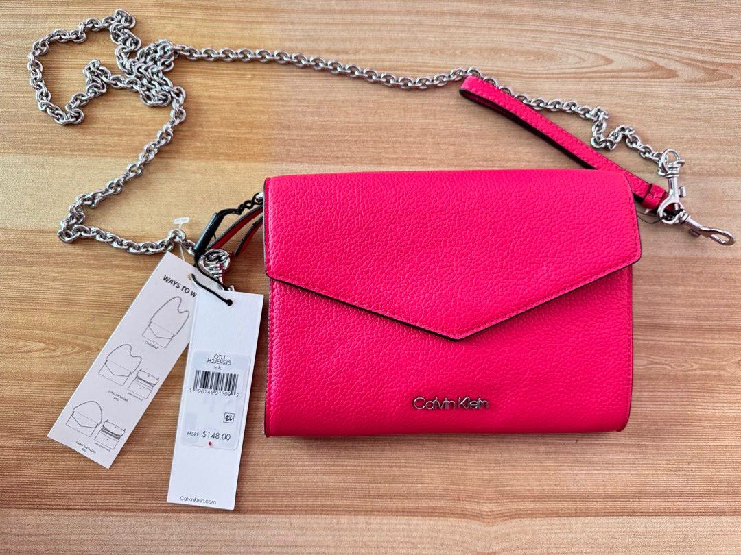 Calvin Klein Pink Crossbody Bag (Category: Cross-body Bags) located in Valenzuela. Submitted by declutterlangpo (Listing ID 1468298903, Image 1). Description: - Brand new with original tags attached (MSRP $148.00) - Eye-catching bright pink color with a chic silver chain strap - Organized interior with multiple compartments, card slots, and a middle zipped pocket - Tag code: H2ER5J3 - Flaw note: Minor paint chipping at the bottom corner edge (pri