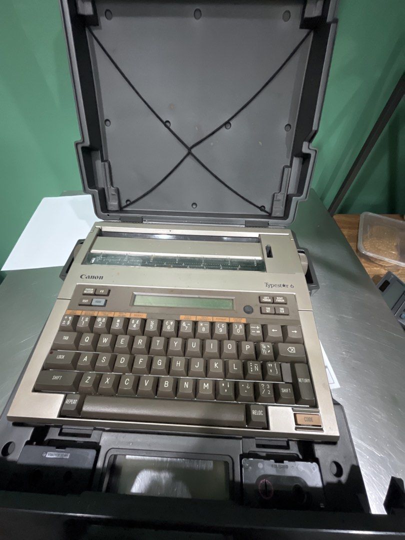 Canon Typestar 6 Portable Electronic Typewriter (Category: Office & Business Technology) located in Mariveles. Submitted by aly0323 (Listing ID 1468389208, Image 2). Description: - Model: Canon Typestar 6 electronic typewriter - Condition: Tested and working, types clearly - Features: Built-in LCD screen, QWERTY keyboard, and compact design - Inclusions: Original carrying case lid - Aesthetic: Retro brown and beige plastic body - Ideal for: Vinta